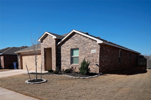 view of front of property featuring a garage, concrete driveway, and brick siding