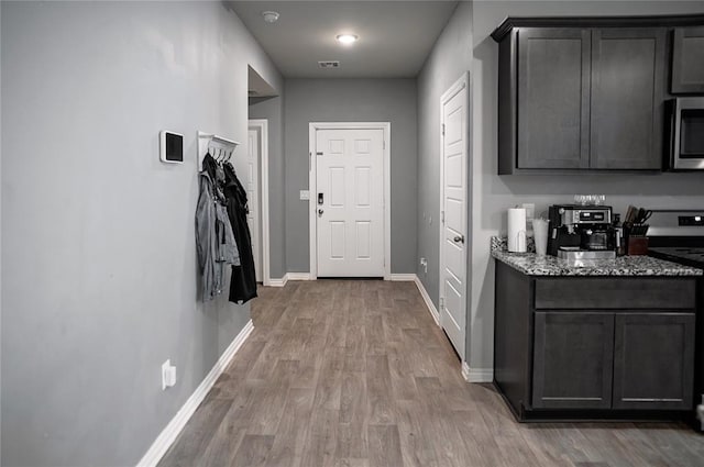 interior space with light wood-type flooring, visible vents, and baseboards