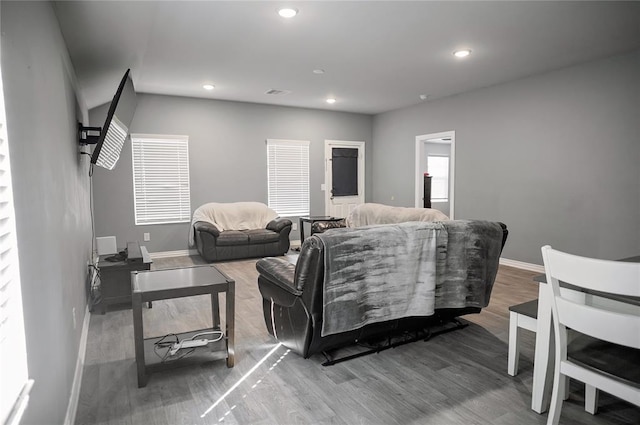 living area featuring recessed lighting, visible vents, baseboards, and wood finished floors