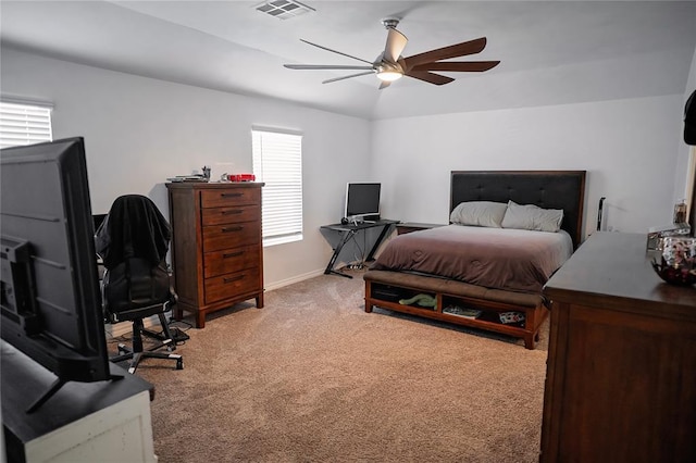 bedroom with baseboards, a ceiling fan, visible vents, and light colored carpet