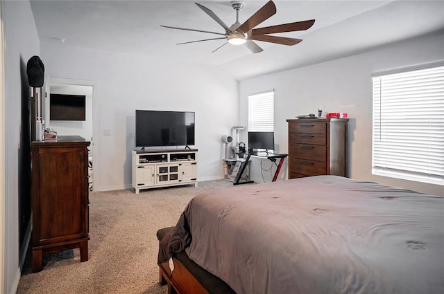 carpeted bedroom with vaulted ceiling, a ceiling fan, and baseboards