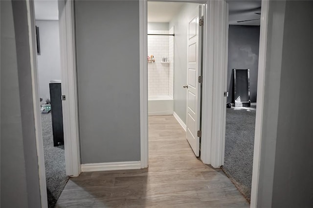 hall with baseboards and wood finished floors