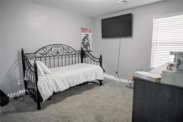 carpeted bedroom with visible vents and baseboards