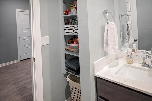 bathroom with baseboards, wood finished floors, and vanity