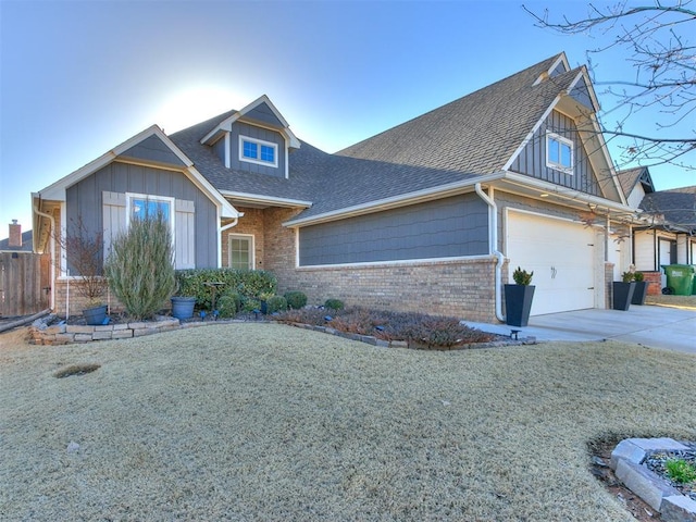 view of front of house with board and batten siding, roof with shingles, concrete driveway, an attached garage, and brick siding