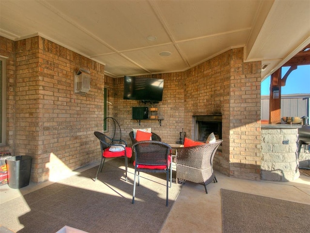 view of patio / terrace featuring an AC wall unit and an outdoor brick fireplace