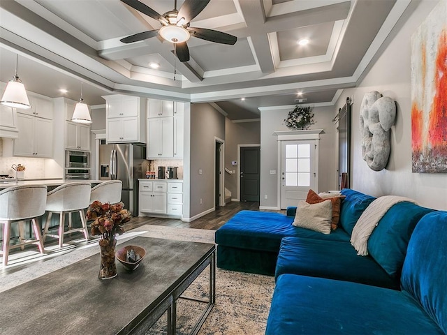 living area featuring baseboards, coffered ceiling, beam ceiling, ceiling fan, and crown molding