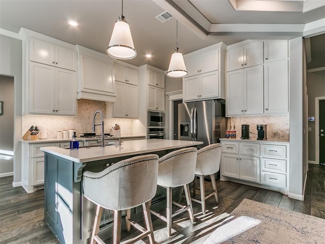 kitchen with dark wood-type flooring, white cabinets, visible vents, and stainless steel appliances