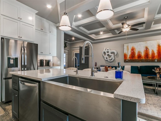 kitchen with backsplash, light stone countertops, open floor plan, coffered ceiling, and stainless steel appliances