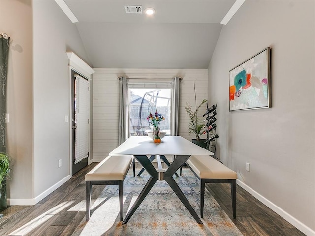 dining room with visible vents, wood finished floors, and vaulted ceiling