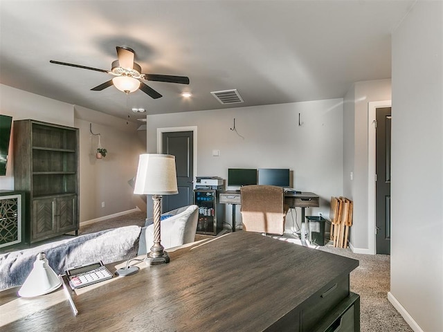 office space featuring visible vents, baseboards, a ceiling fan, and carpet flooring