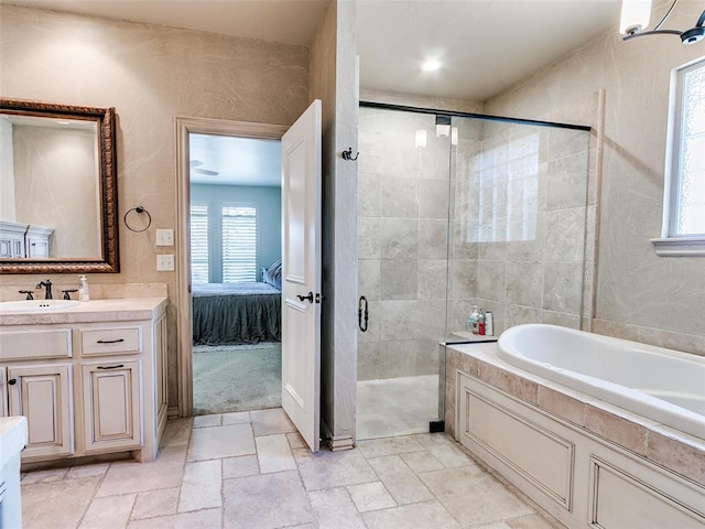 ensuite bathroom with connected bathroom, vanity, a bath, a stall shower, and stone tile flooring