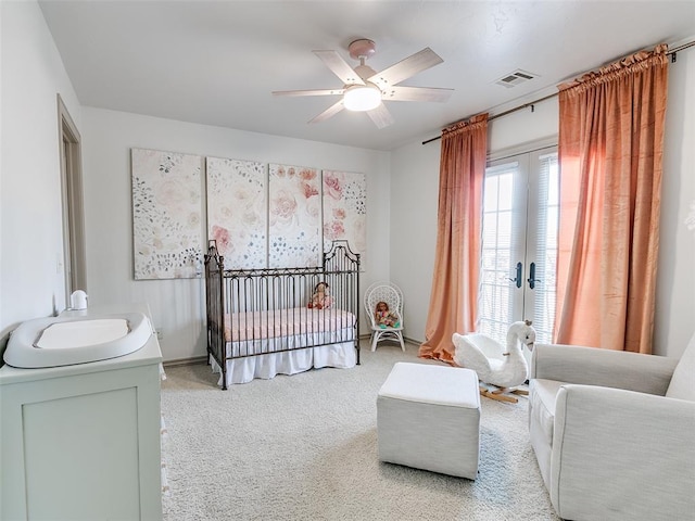 bedroom featuring french doors, light colored carpet, visible vents, a ceiling fan, and a sink