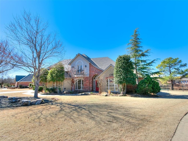 view of front of property featuring fence and brick siding