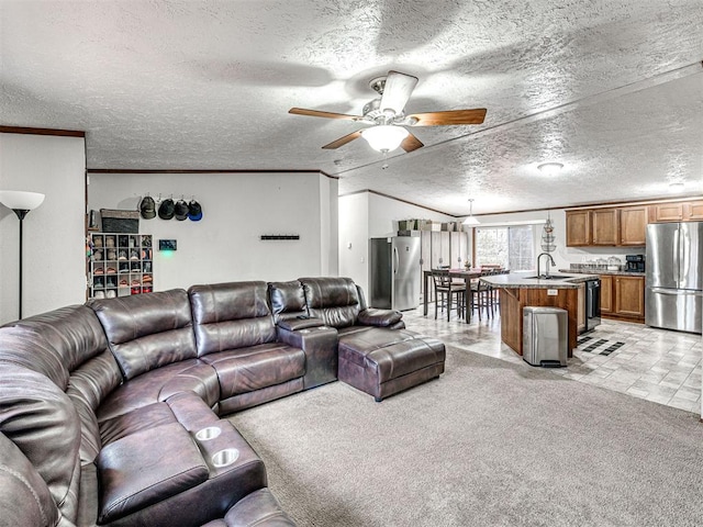 living room with a textured ceiling, ornamental molding, a ceiling fan, and light colored carpet