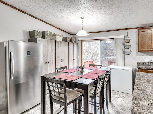 dining space featuring a textured ceiling and crown molding