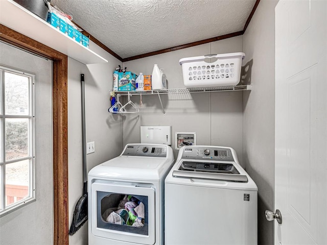 washroom featuring laundry area, washing machine and dryer, a textured ceiling, and crown molding