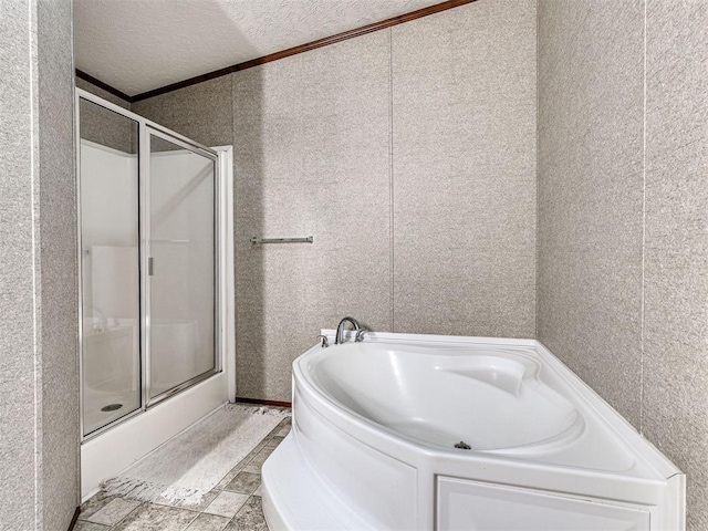 full bathroom featuring a textured ceiling, a shower stall, and a bath