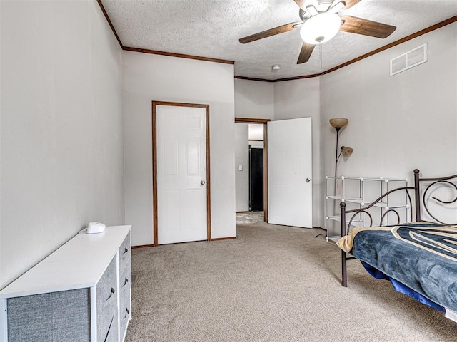 bedroom featuring light carpet, a textured ceiling, visible vents, and crown molding