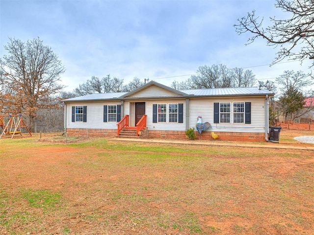 ranch-style home with entry steps, metal roof, a front lawn, and a playground