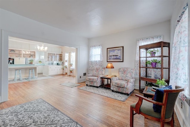 living area with a notable chandelier and light wood-type flooring