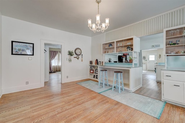 interior space with light wood-style flooring, baseboards, and a chandelier