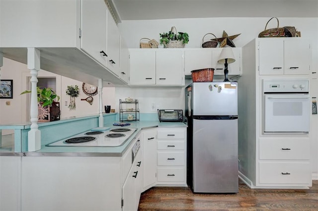 kitchen featuring dark wood-style floors, white cabinets, white appliances, and light countertops