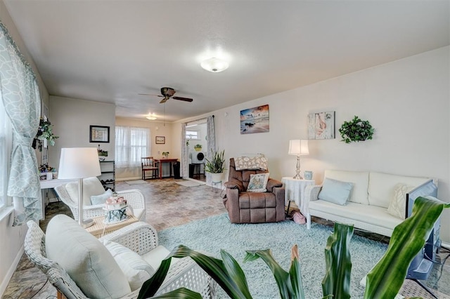 living room with ceiling fan and baseboards