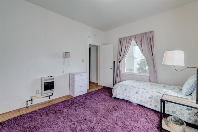 bedroom featuring heating unit and carpet