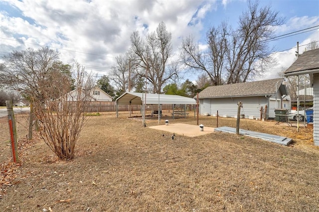 view of yard featuring fence and a carport