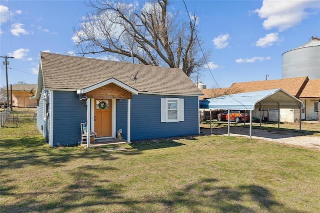 bungalow featuring a shingled roof, dirt driveway, fence, a front lawn, and a carport