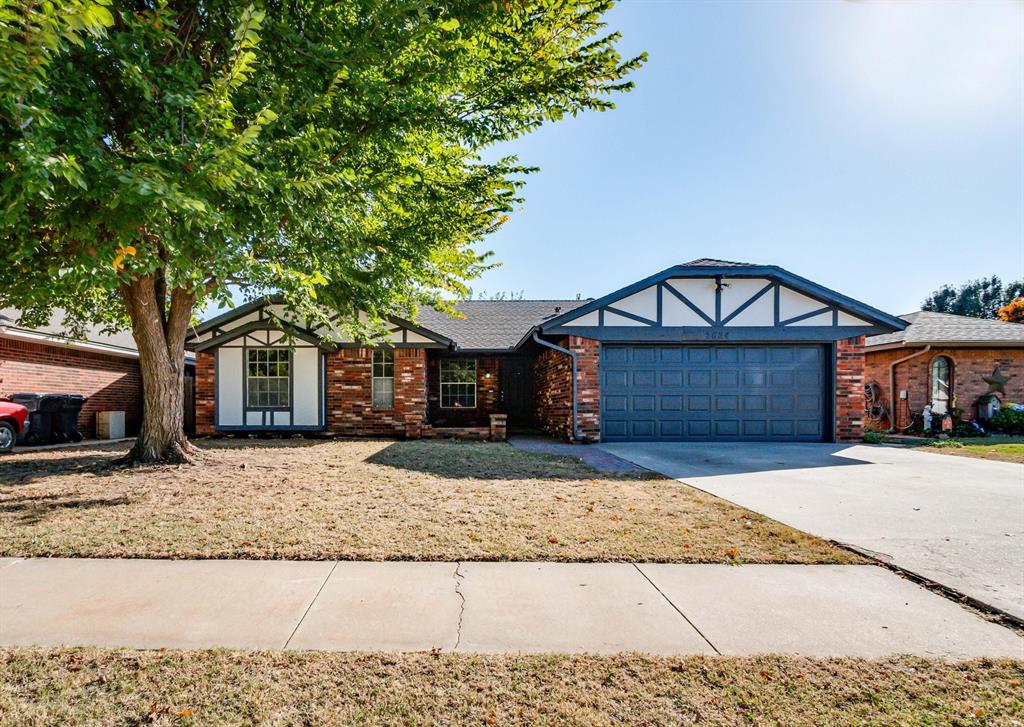 view of front of property with brick siding, driveway, and an attached garage