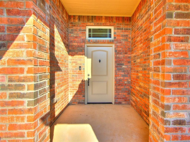 view of exterior entry with brick siding