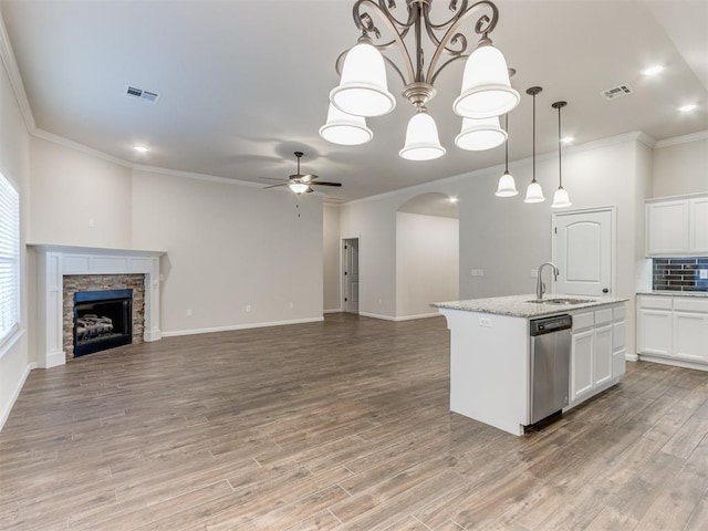 kitchen featuring a fireplace, a sink, visible vents, open floor plan, and stainless steel dishwasher