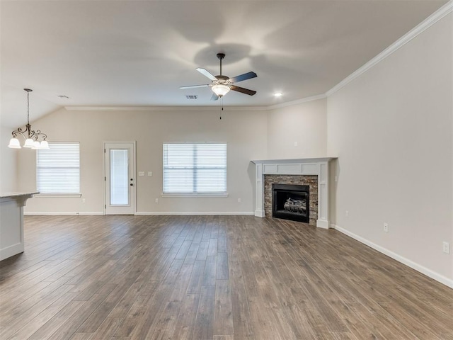 unfurnished living room featuring crown molding, a healthy amount of sunlight, a fireplace, and wood finished floors