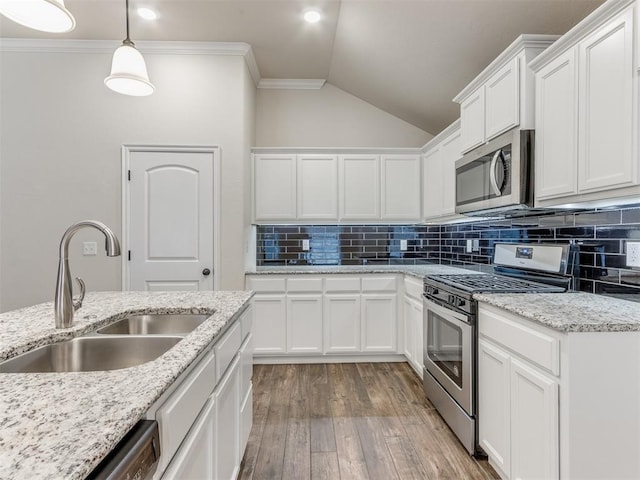 kitchen with light wood-style flooring, a sink, white cabinets, appliances with stainless steel finishes, and crown molding