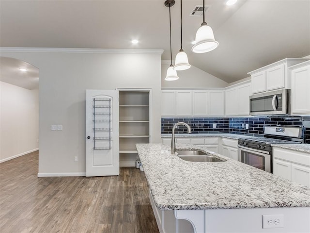 kitchen with visible vents, decorative backsplash, appliances with stainless steel finishes, a sink, and an island with sink