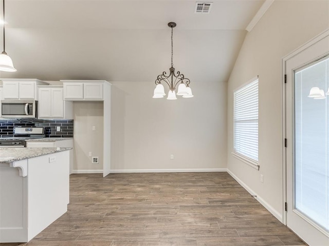 kitchen featuring tasteful backsplash, visible vents, lofted ceiling, appliances with stainless steel finishes, and light wood-type flooring