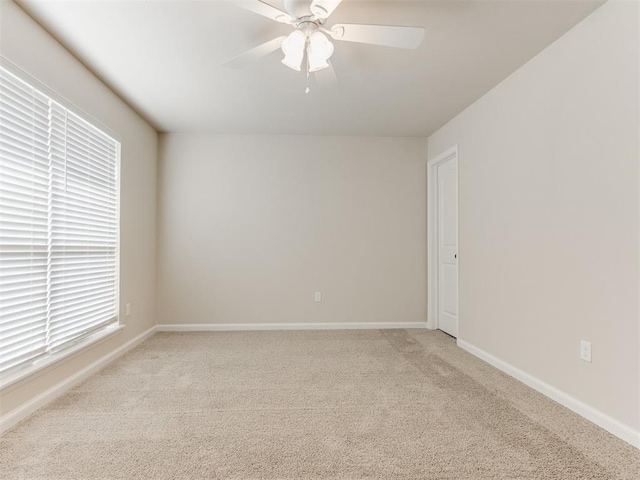 unfurnished room with light carpet, plenty of natural light, ceiling fan, and baseboards