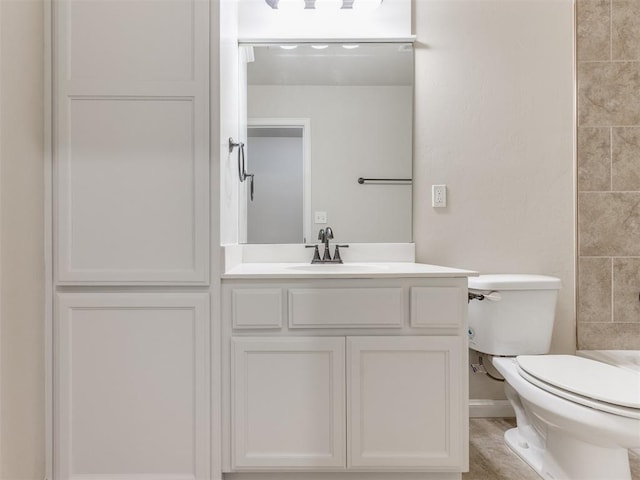 bathroom featuring toilet, a shower, and vanity