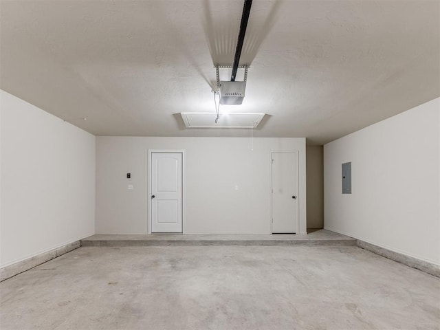 garage with a garage door opener, electric panel, and baseboards