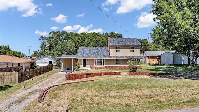 view of front of home featuring brick siding, a shingled roof, fence, dirt driveway, and a front yard