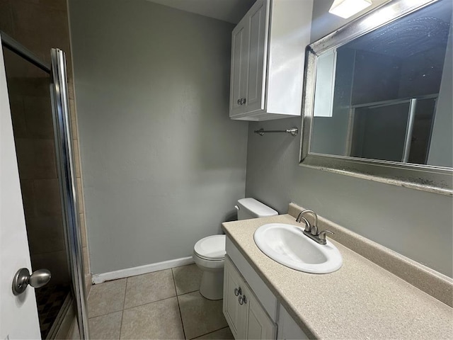 bathroom featuring vanity, baseboards, a stall shower, tile patterned floors, and toilet