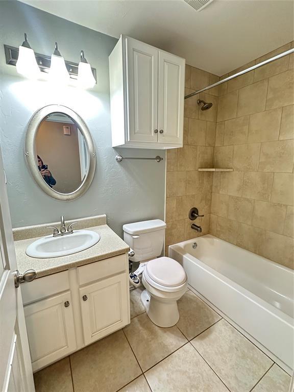 bathroom with vanity, tile patterned floors, toilet, and shower / bathing tub combination