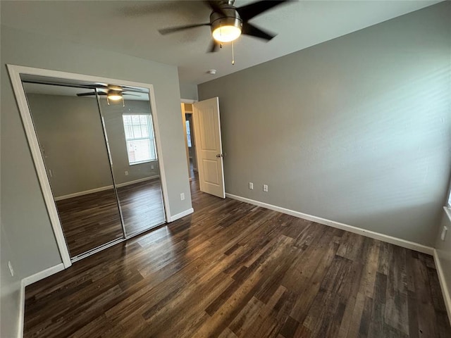 unfurnished bedroom with a closet, baseboards, wood finished floors, and a ceiling fan