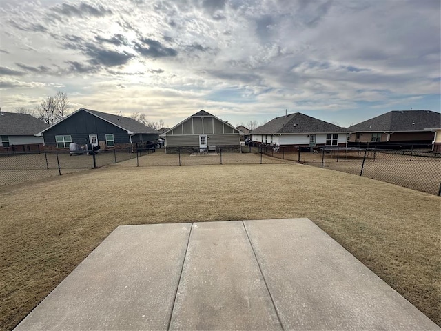 view of yard with a patio, a fenced backyard, and a residential view