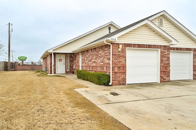 ranch-style home featuring a garage, brick siding, fence, driveway, and a front yard