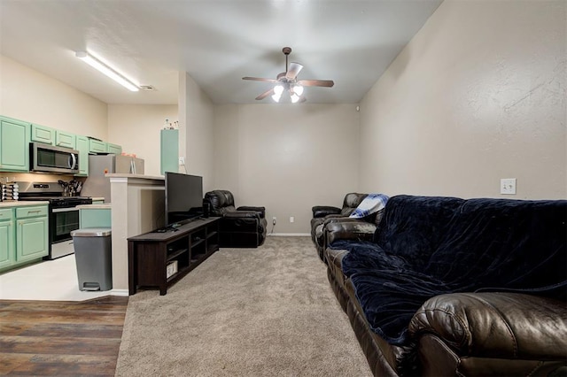 carpeted living room featuring a ceiling fan and baseboards