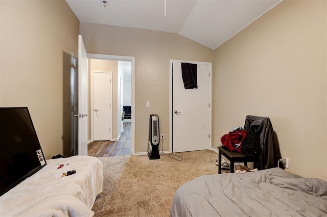 bedroom featuring lofted ceiling, baseboards, and carpet floors