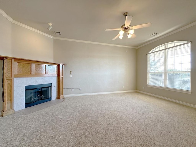 unfurnished living room featuring a tiled fireplace, baseboards, crown molding, and light colored carpet